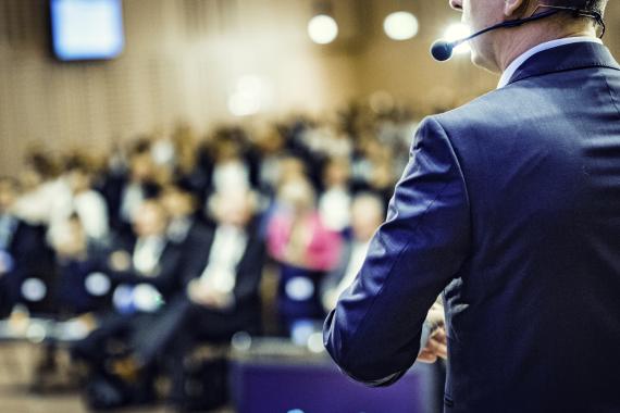 Rear view of a lecture to a sold-out crowd in a lecture hall