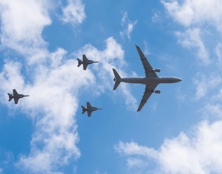 KC-135 aerial refueling tanker aircraft flying over clouds during a training mission